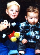 Photo of two toddlers holding a plush toy